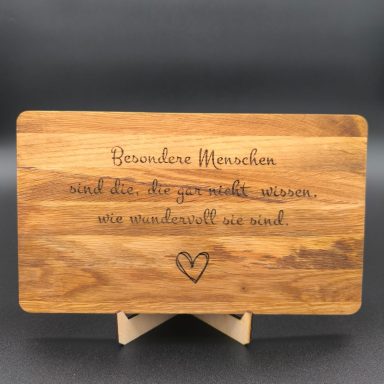 Holztafel mit graviertem Zitat über bemerkenswerte Menschen und ein Herzsymbol.